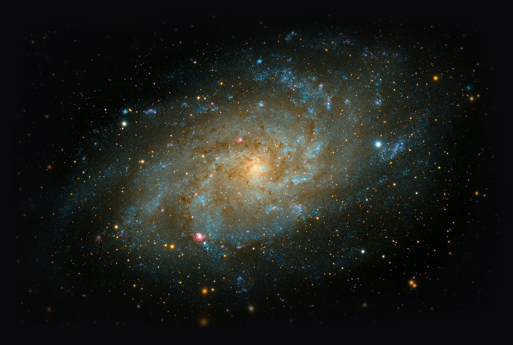 A detailed view of a spiral galaxy with bright stars, glowing nebulae, and swirling blue and golden star fields in deep space.